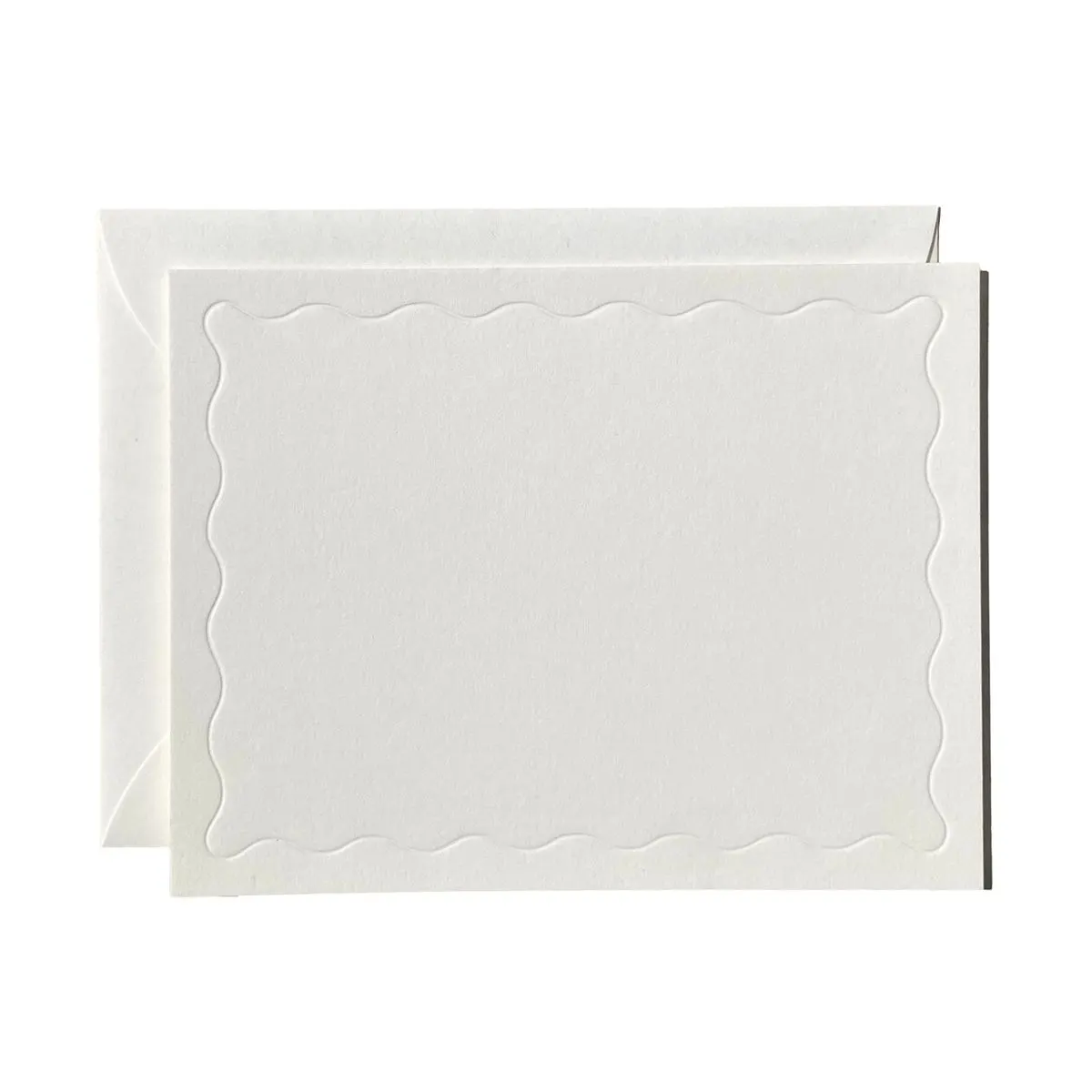 A blank scalloped card resting on its envelope